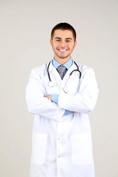 Man dokter staan op grijze achtergrond — Stockfoto