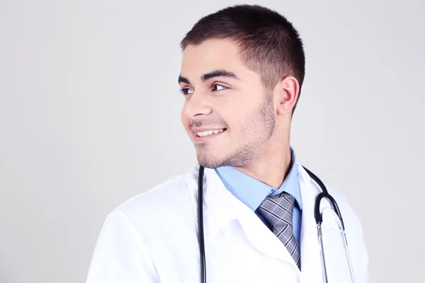 회색 배경 위에서 있는 남성 의사 — 스톡 사진