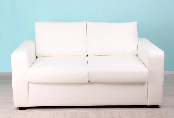 青色の背景のある部屋で白いソファ — ストック写真