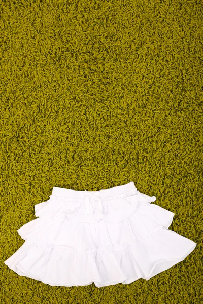 Vacker kjol för liten flicka på gröna mattan — Stockfoto
