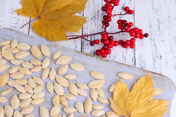 Семена тыквы на деревянной стойке на столе вблизи
