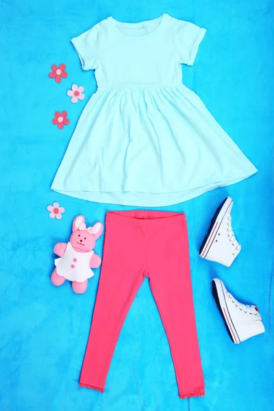 Beautiful clothes for little girl on blue background — Stock Photo, Image