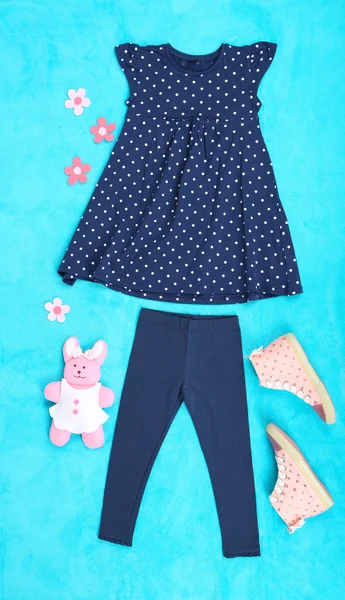 Beautiful clothes for little girl on blue background — Stock Photo, Image