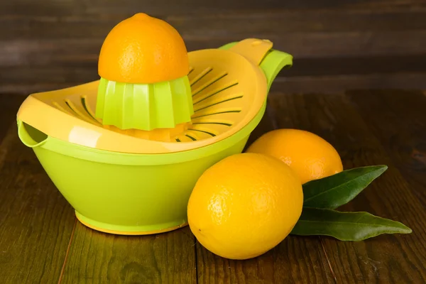 Lis na citrusy a citrony na stole na dřevěné pozadí — Stock fotografie