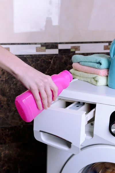 Les mains féminines versé de la poudre dans la machine à laver close-up — Photo