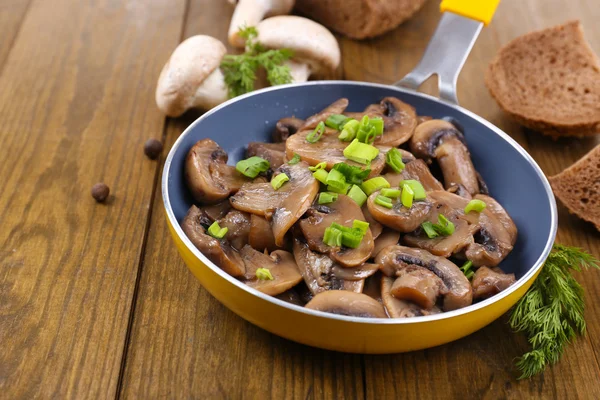 Deliciosos cogumelos fritos na panela na mesa close-up — Fotografia de Stock
