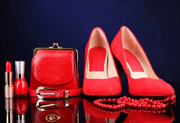 Beautiful red female accessories and cosmetics, on blue background — Stock Photo, Image