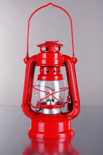 Red kerosene lamp on grey background