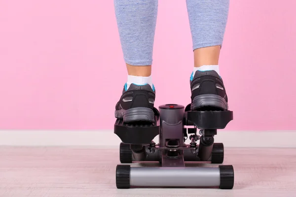 Woman doing exercise on stepper. Close-up on legs. — Stock Photo, Image