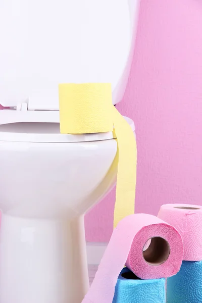 Vasul de toaletă alb și role colorate de hârtie igienică, în baie — Fotografie, imagine de stoc