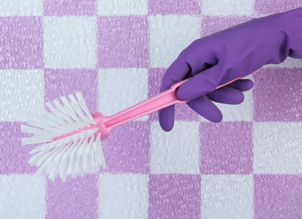 Toilet brush in hand on tile wall background — Stock Photo, Image