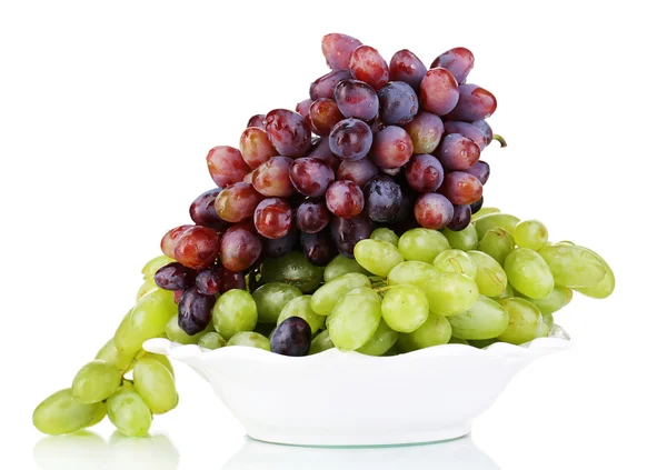 Спелые зеленый и фиолетовый виноград на тарелке изолированы на белом — стоковое фото