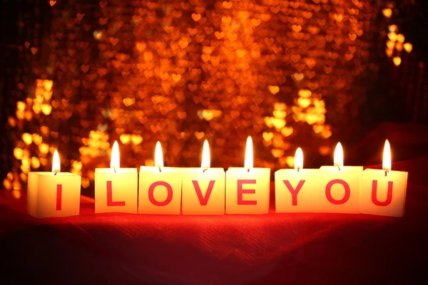 Candles with printed sign I LOVE YOU,on blur lights background — Stock Photo, Image