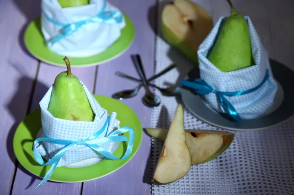 Päron i servetter på tallrikar på träbord närbild — Stockfoto