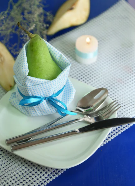 Päron i servett på plattan på träbord närbild — Stockfoto