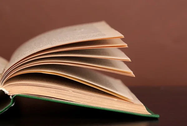 Открытая книга на деревянном столе на цветном фоне — стоковое фото