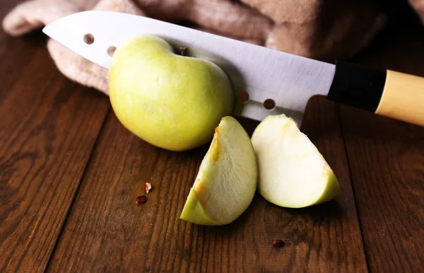 Nóż kuchenny i zielone jabłko, na drewnianym tle — Zdjęcie stockowe