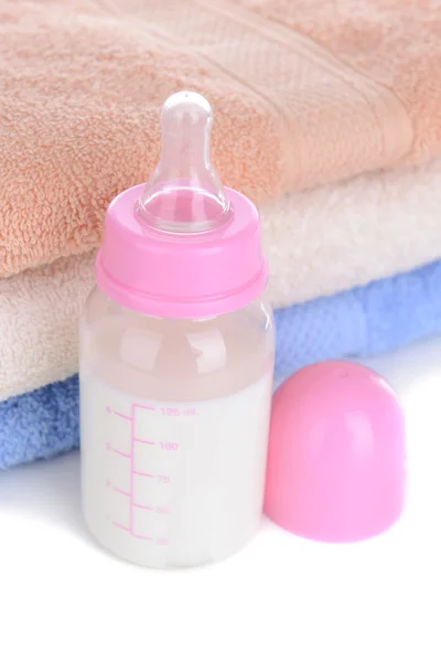 Baby bottle with milk and towels close-up — Stock Photo, Image