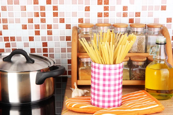 Maceta en la estufa en la cocina en la mesa en el fondo de mosaico azulejos —  Fotos de Stock