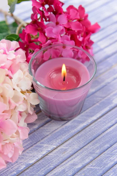 Belas velas coloridas e flor, na cor de fundo de madeira — Fotografia de Stock