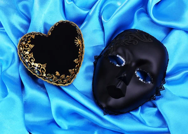 Decorative black heart and mask, on color fabric — Stock Photo, Image