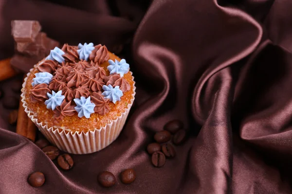 Leckere Cupcake mit Buttercreme, auf farbigem Stoff Hintergrund — Stockfoto