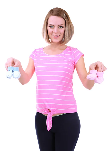 年轻的怀孕女子捧着孤立的白色衬底上的蓝色和粉红色的婴儿鞋 — 图库照片