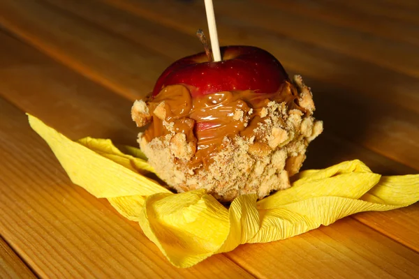 Kandierter Apfel am Stock auf Holztisch — Stockfoto