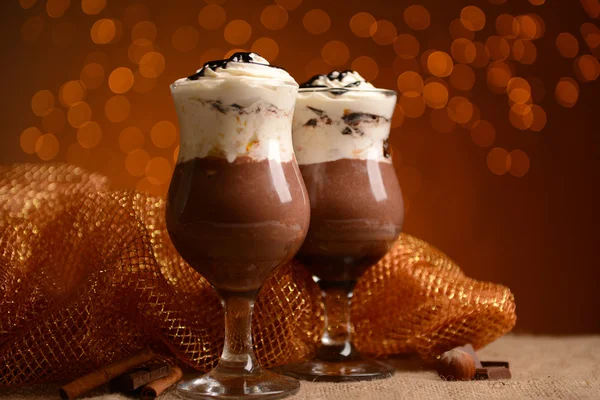 Leckeres Dessert mit Schokolade, Sahne und Orangensoße, auf dem Tisch, auf hellem Hintergrund — Stockfoto