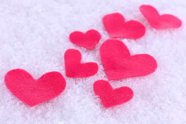 Pequeños corazones sentidos sobre fondo nevado — Foto de Stock