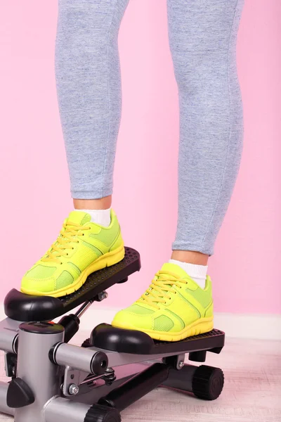 Woman doing exercise on stepper. Close-up on legs. — Stock Photo, Image