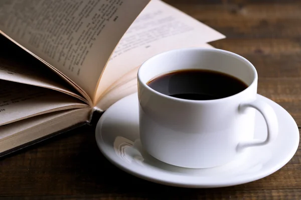 Tasse heißen Kaffee mit Buch auf Holzgrund — Stockfoto