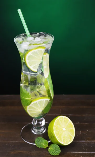 Glass 的鸡尾酒与石灰和薄荷上深绿色的背景表格 — 图库照片