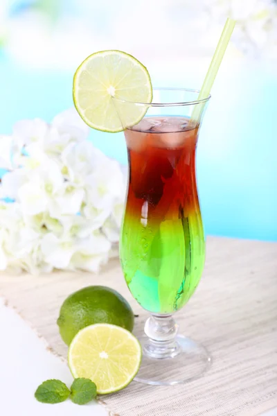 Glas Cocktail auf Tisch auf hellblauem Hintergrund — Stockfoto