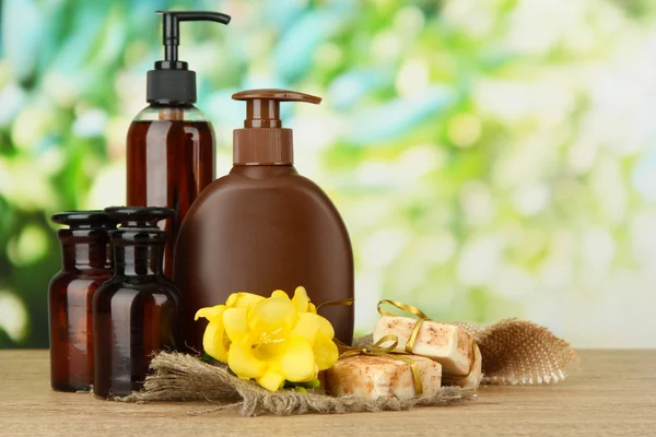 Flüssige und handgemachte Seifen auf Holztisch, auf grünem Hintergrund — Stockfoto