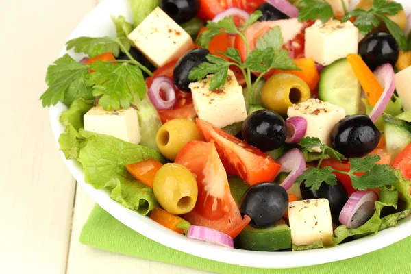 Salade fraîche dans une assiette sur une table en bois — Photo