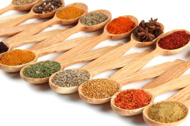 Tahta kaşıklardaki çeşitli baharatlar, beyaz kaşık üzerinde izole edilmiş.