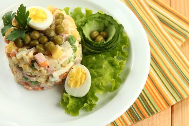 Rus salatası geleneksel ahşap arka plan üzerinde renkli peçete üzerinde olivier