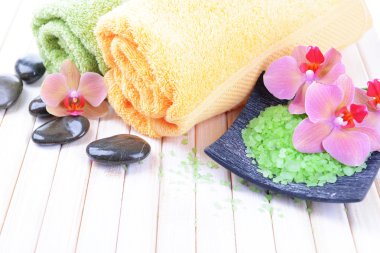 güzel çiçek ile natürmort orkide çiçek, havlu ve deniz tuzu, renk ahşap arka plan üzerine bir kase