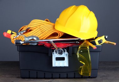 gri zemin üzerine ahşap masa üstünde alet ile siyah toolbox