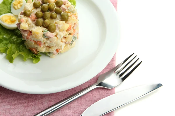 Salada tradicional russa Olivier em prato branco, em guardanapo de cor, isolado em branco — Fotografia de Stock