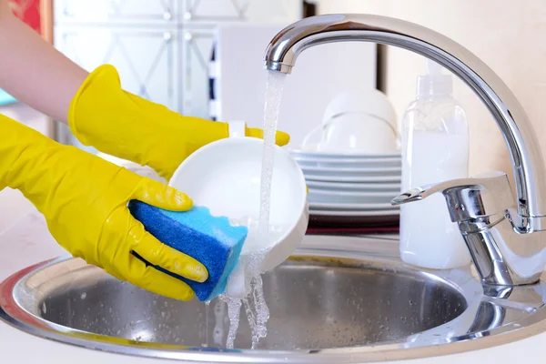 Cerrar las manos de la mujer lavando platos en la cocina — Foto de Stock