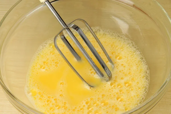 Cooking, whipping eggs with electric whisk in bowl, close up — Stock Photo, Image