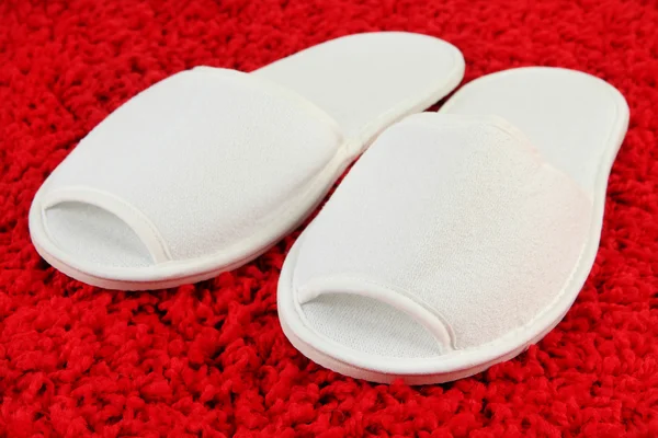 Pantoufles blanches sur fond de tapis — Photo