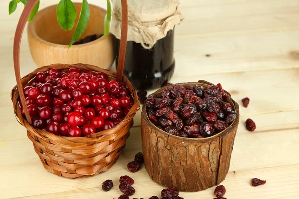 Cranberry fresco e seco em cestas na mesa de madeira — Fotografia de Stock