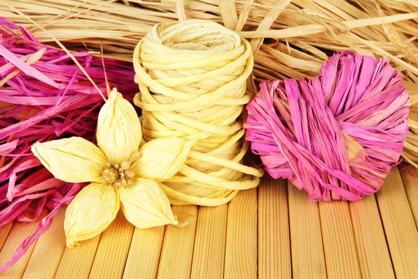 Decoratieve stro voor met de hand gemaakt, bloem en hart van stro, op houten achtergrond — Stockfoto