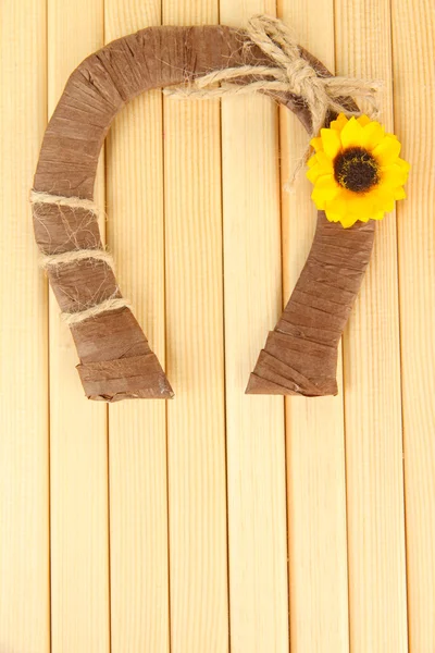 Herradura decorativa de paja con girasol, sobre fondo de madera — Foto de Stock