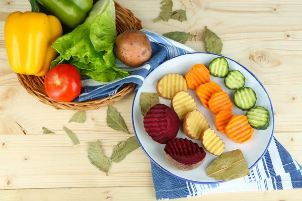Красивые нарезанные овощи, на тарелке, на деревянном фоне — стоковое фото