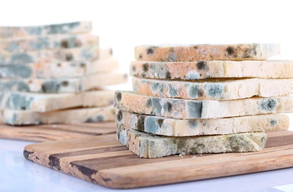 Mouldy bread on cutting board, isolated on white — Stock Photo, Image