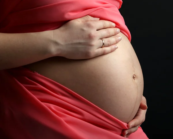 Zwangere vrouw met koraal materiaal geïsoleerd op zwart — Stockfoto